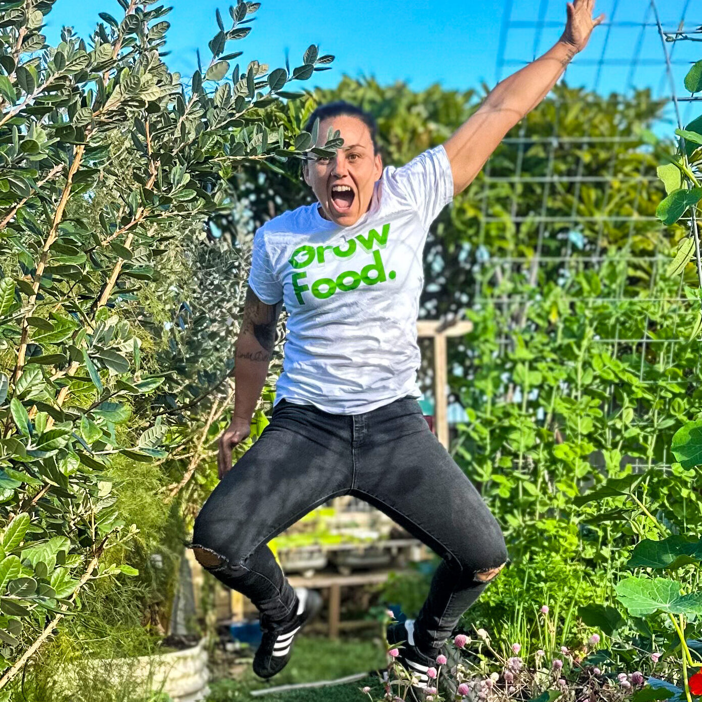 Person jumping joyfully in lush garden