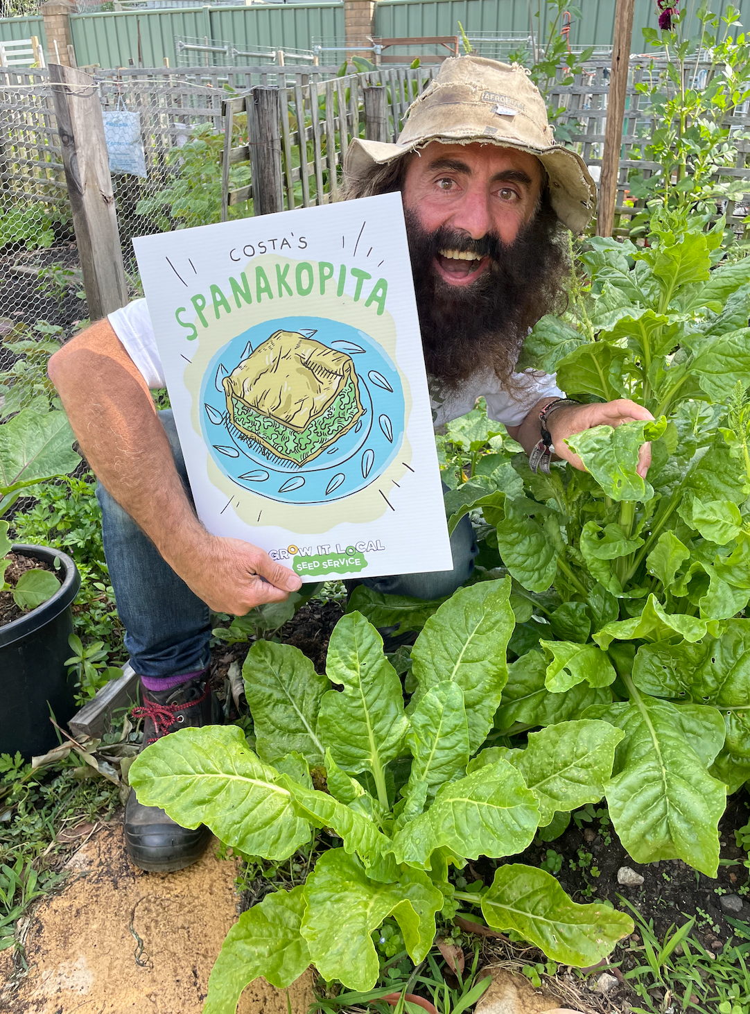 Person with Spanakopita sign in vegetable garden