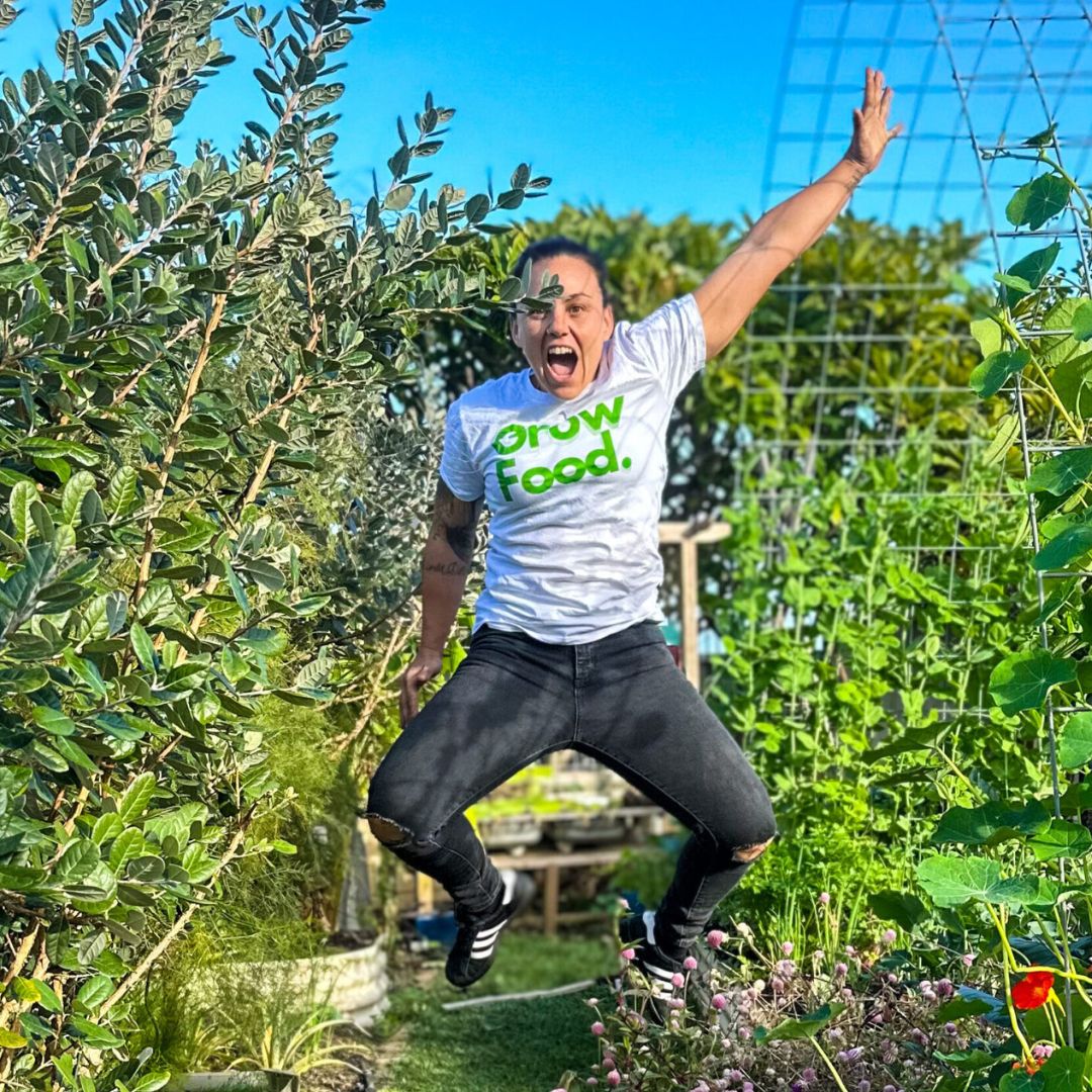 Person jumps in lush garden