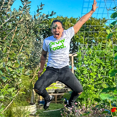 Person jumping in a lush garden.