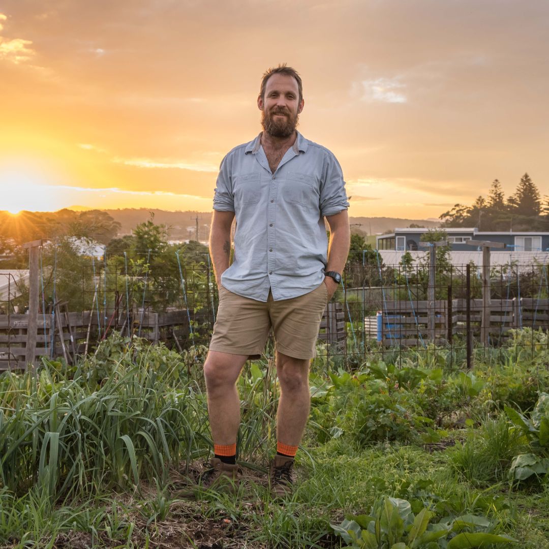 Man standing in a garden at sunset