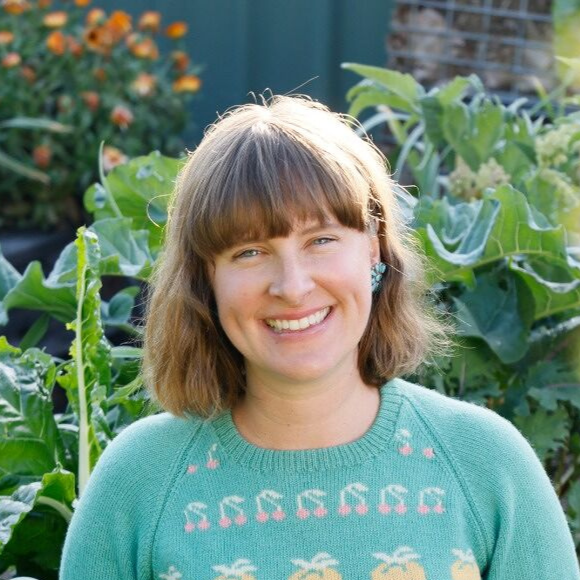 Smiling person in garden with greenery.