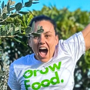 Person excitedly promotes food growing outdoors.