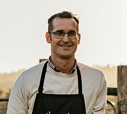 Chef standing outside wearing The Agrarian Kitchen apron.